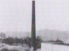 Na fotografii je zachytená demolácia 60 m vysokého komína v roku 1976 v Nových Nosiciach. Pôvodne patril tehelni z roku 1900, ktorej činnosť ukončilo v 70. rokoch vyťaženie suroviny.