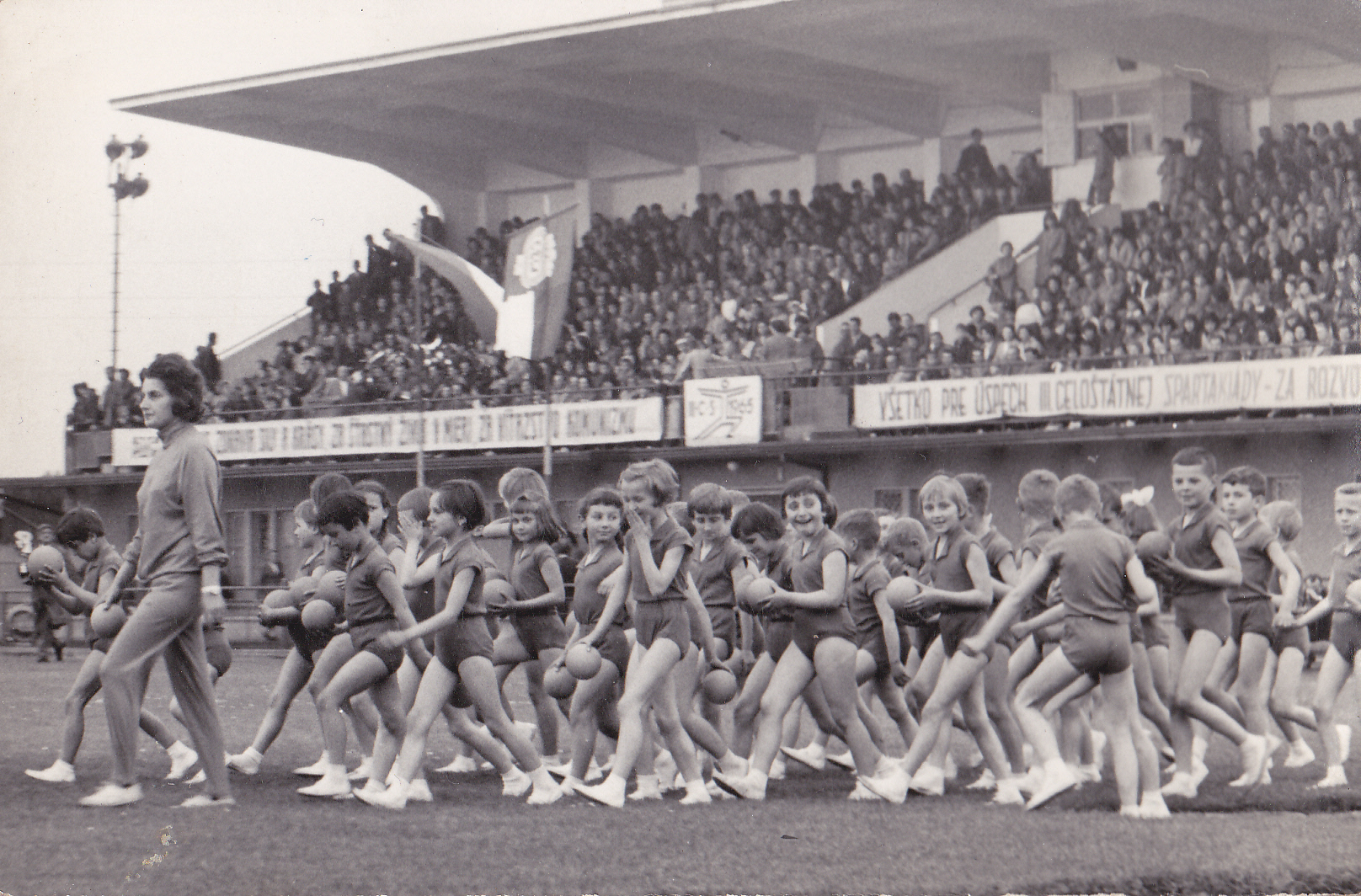 Pani učiteľka Mončeková vedie svojich zverencov na cvičenie (Spartakiáda) na štadióne v Púchove 5. júna 1965