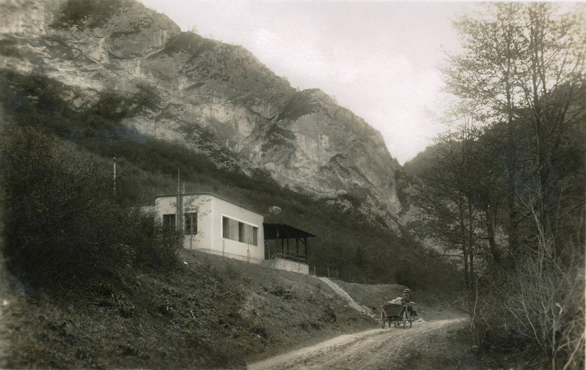 Fotografia Skautského domu (1932-1939) v Belušských Slatinách a na ceste pod ním povoz smerujúci ku kamenným vrátam a ďalej do Mojtína. V roku 1939 zabrala túto budovu Hlinkova garda a v roku 1944 ju počas SNP zničili nemeckí vojaci. V blízkosti tohto miesta tu od roku 1964 stojí chata Požiarnik