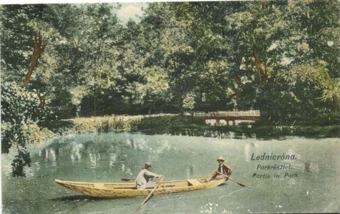 Kolorovaná fotografia z prelomu 19. a 20. storočia zachytila člnkujúcich sa pánov na jazierku v historickom parku Lednické Rovne.