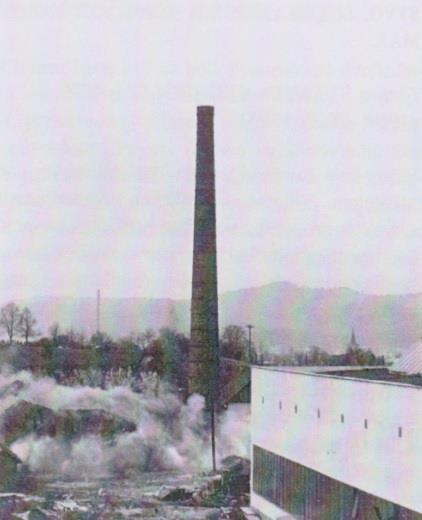 Na fotografii je zachytená demolácia 60 m vysokého komína v roku 1976 v Nových Nosiciach. Pôvodne patril tehelni z roku 1900, ktorej činnosť ukončilo v 70. rokoch vyťaženie suroviny.