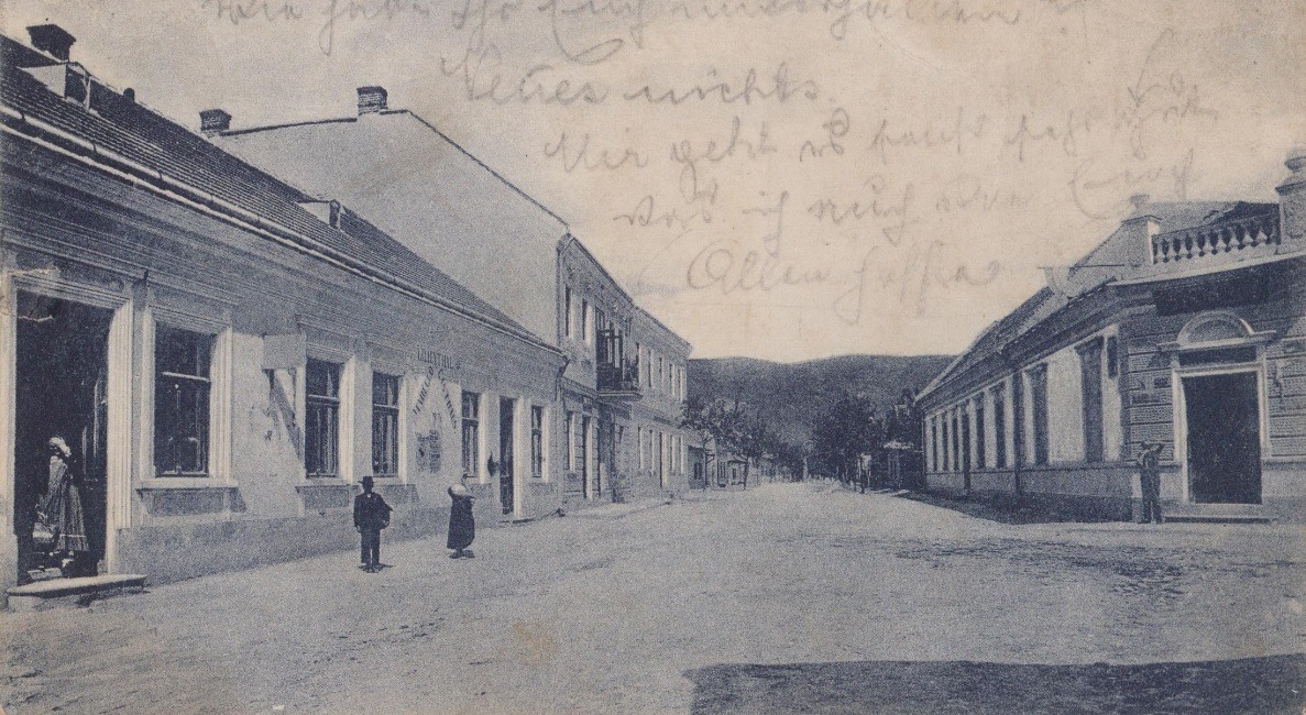 Pohľad na Moravskú ulicu v Púchove na začiatku 20. storočia: fotograf zachytil križovatku s dnešnou pešou zónou, pričom vľavo vidieť Hotel Lilienthal, za ním poschodovú budovu Židovskej školy a oproti na rohu dom obchodníka Nathana.