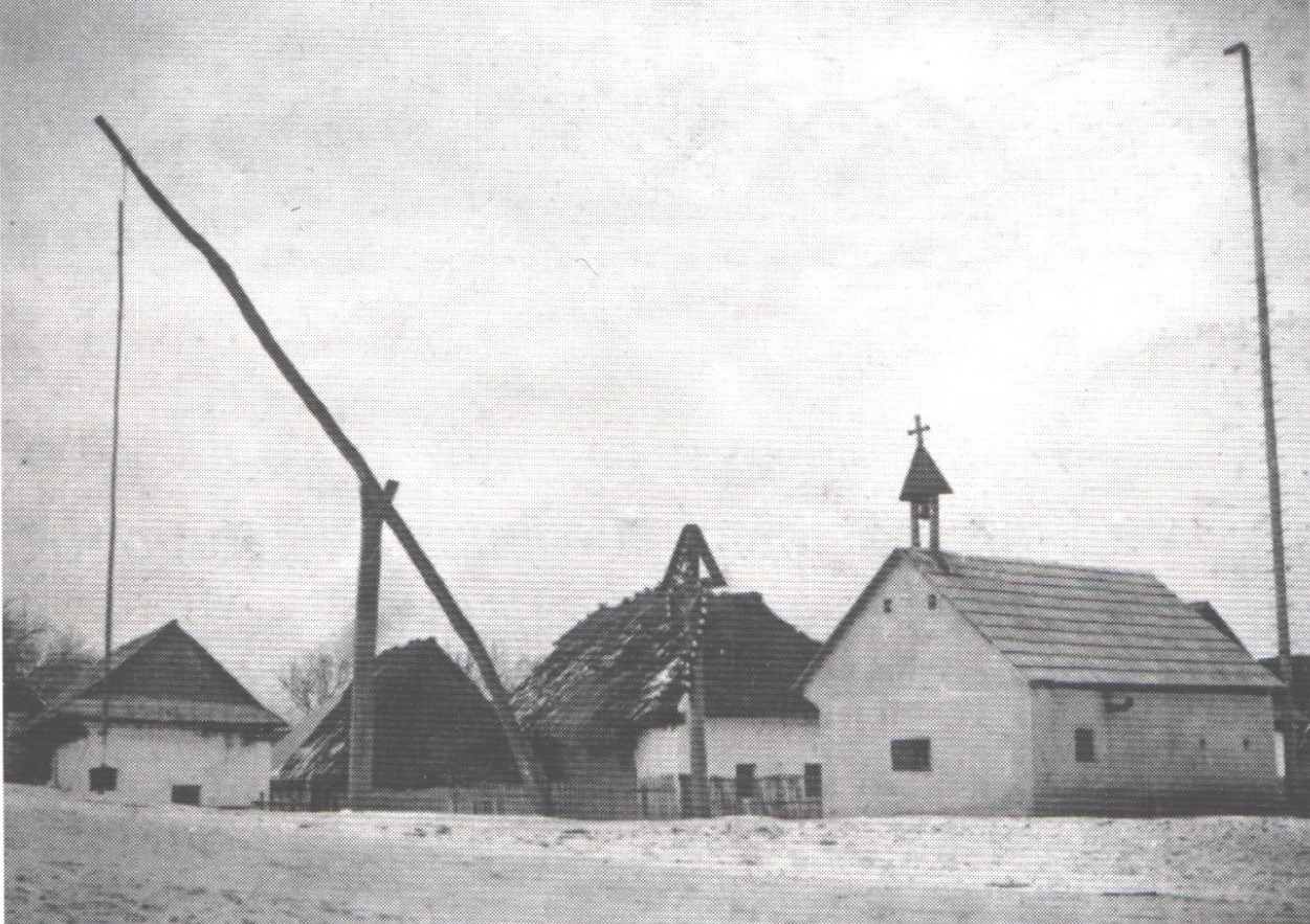 Požiarna zbrojnicu so zvonicou, krížom a vahadlovou studňou v roku 1900 v Dolných Kočkovciach